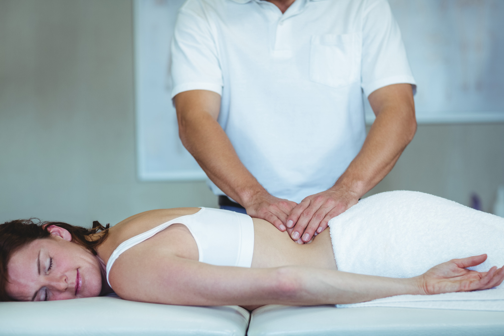 Massage therapist providing targeted back treatment in a clinical setting